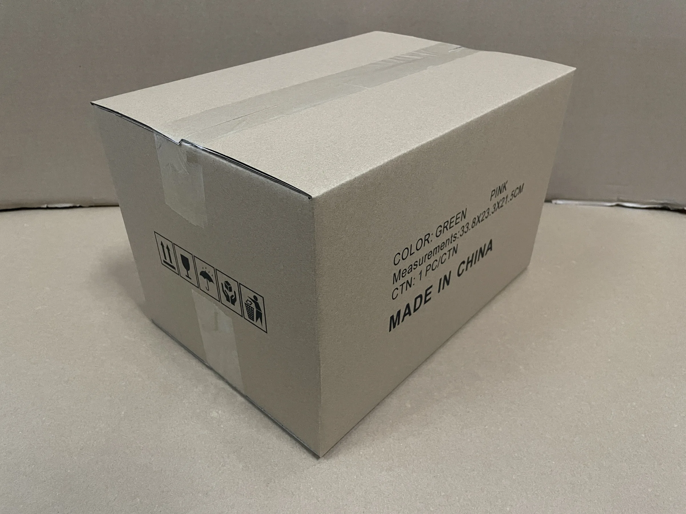 Closed cardboard carton with handling symbols and printed size and quantity information