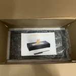 Open shipping carton with a protected tabletop ethanol fireplace and instruction sheet