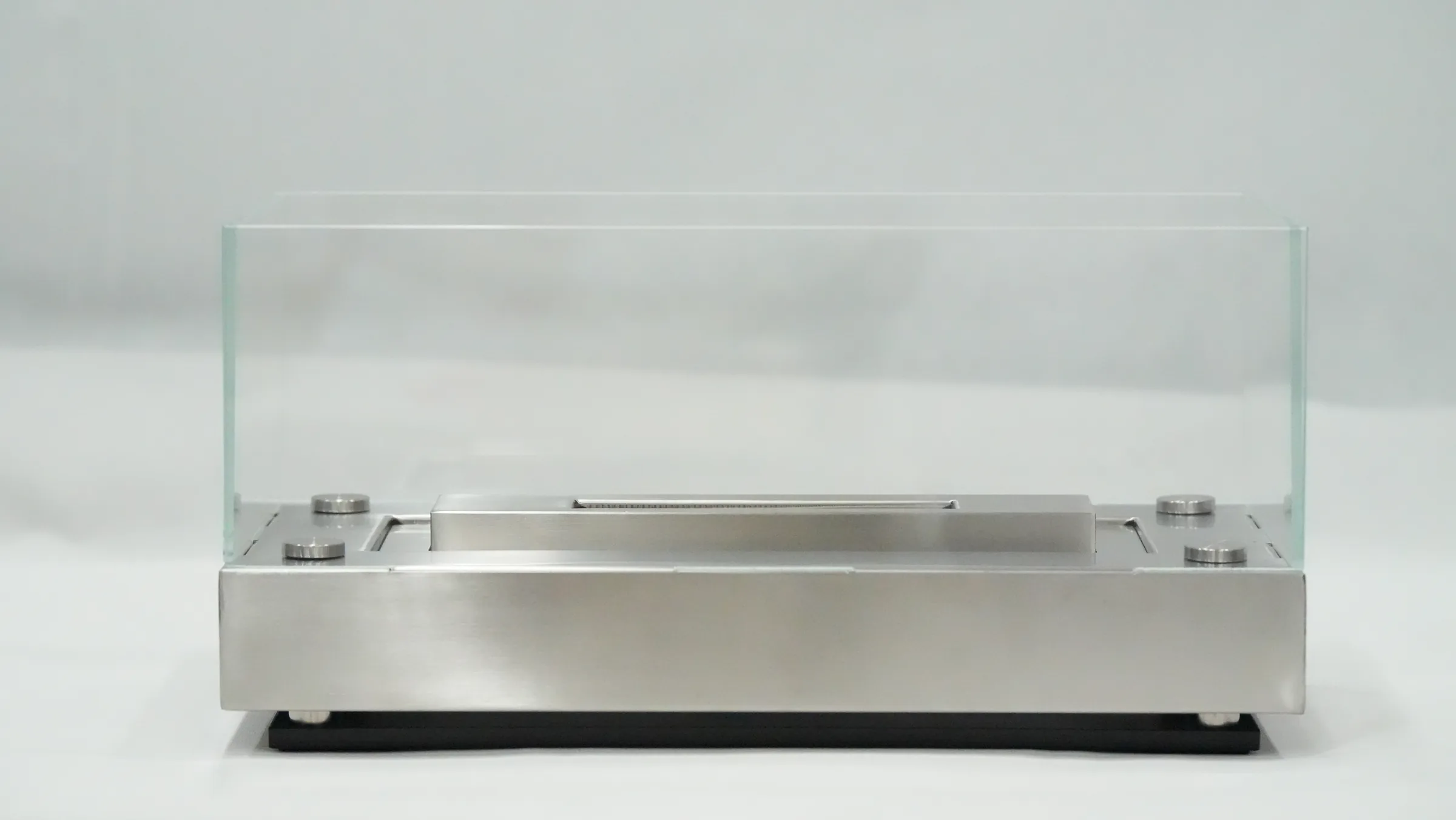 Front view of a rectangular metal tabletop fireplace with glass guards and a central burner